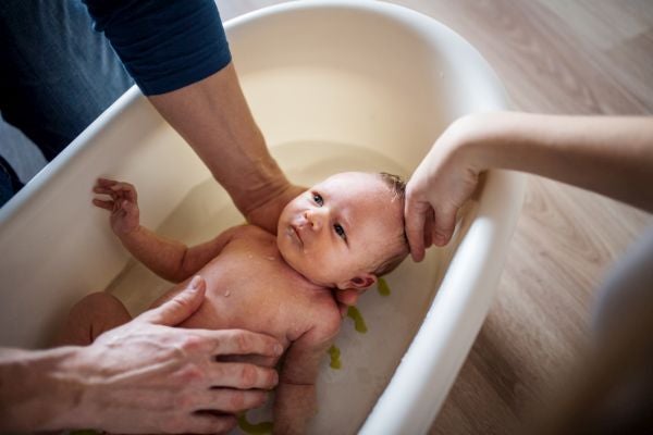 Baby mit Erkältung wir von Papa gebadet