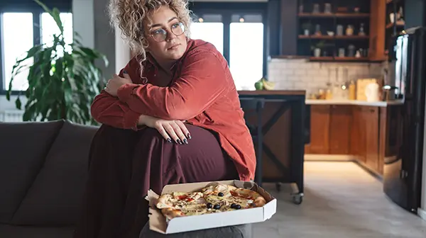 Junge Frau mit Adipositas kämpft gegen emotionales Essen 