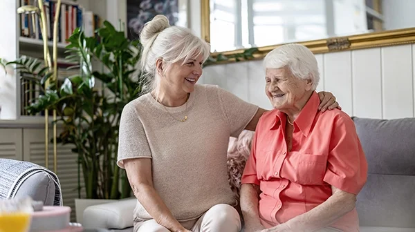 Haushaltshilfe hilft einer Seniorin in der Küche