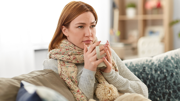 Frau mit Grippe Symptomen auf dem Sofa