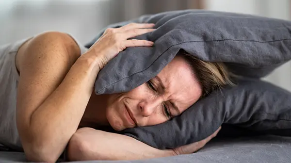 Frau kann wegen ihres Tinnitus nicht einschlafen