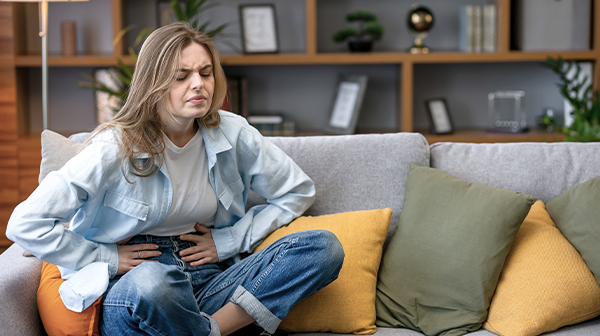 Junge Frau mit Morbus Crohn hat Schmerzen