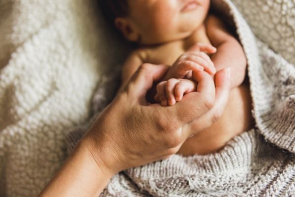 Mutter hält Händchen des Babys