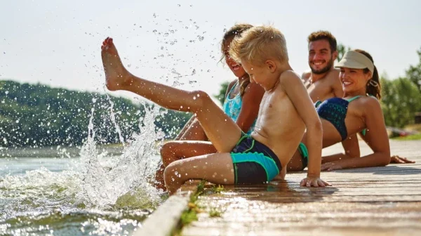Eine Familie sitzt im Sommer auf einem Steg